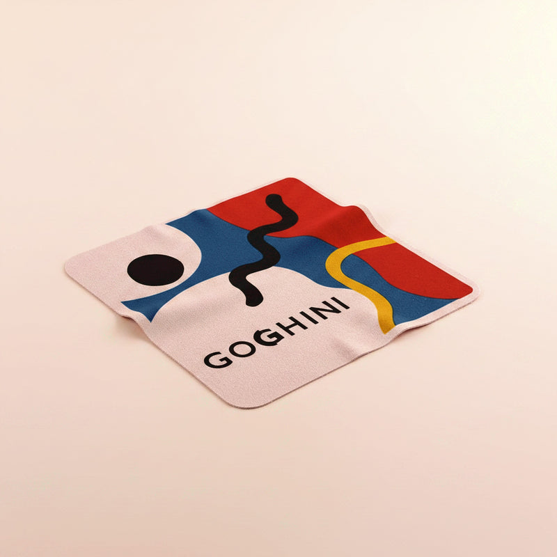 Pink GOGHINI microfibre cleaning cloth resting on a surface, artwork panel visible