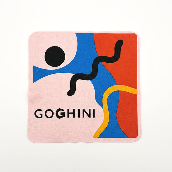 Pink GOGHINI microfibre cleaning cloth lying flat, abstract face artwork and GOGHINI wordmark
