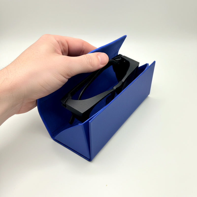 Hands placing folded Focus Frames into the open triangular GOGHINI glasses case
