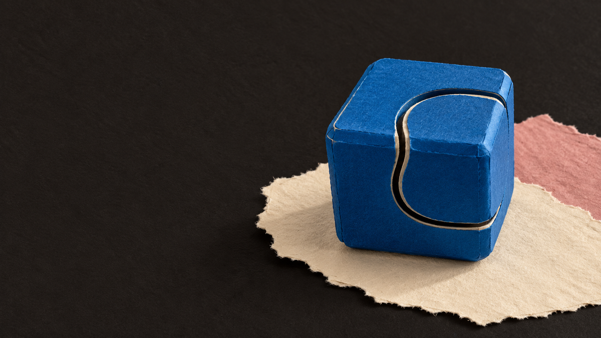 Paper interpretation of the blue interlocking fidget cube, with black title space.