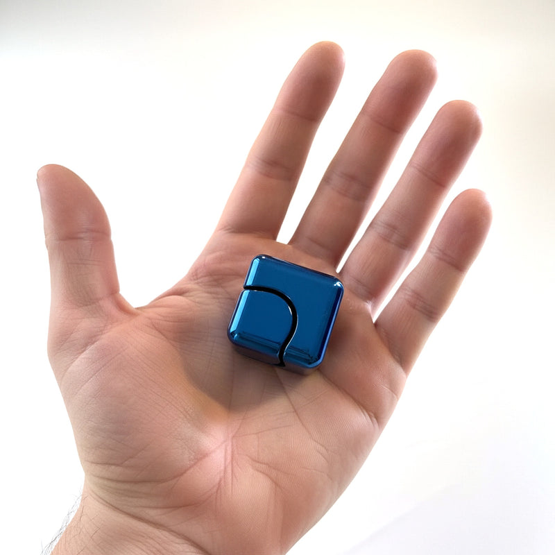Blue anodised metal fidget cube held in an open palm